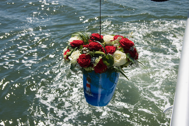Urne mit der Asche des Verstorbenen über dem Wasser